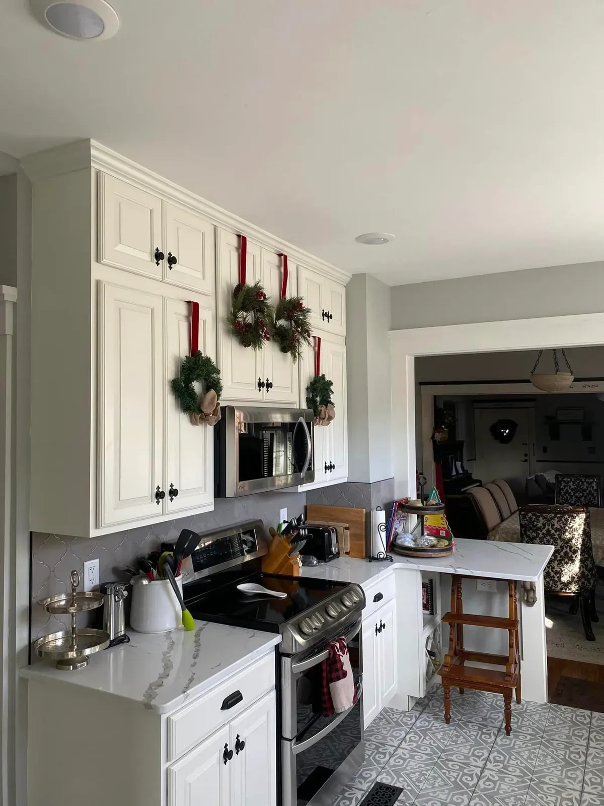 White kitchen cabinets with stainless appliances and a tile floor